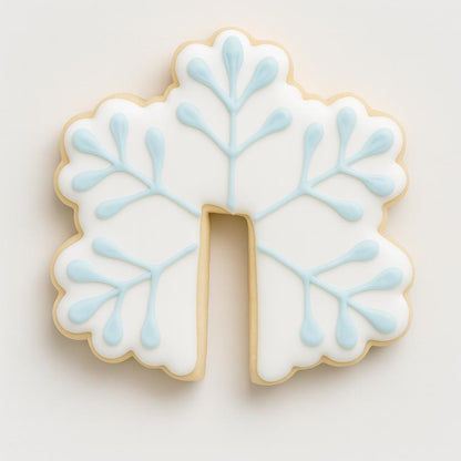 A white snowflake-shaped mug hugger cookie with light blue icing details and a small cutout at the bottom to fit over a mug rim. The design is simple, elegant, and festive, adding a cozy winter touch to any hot drink.