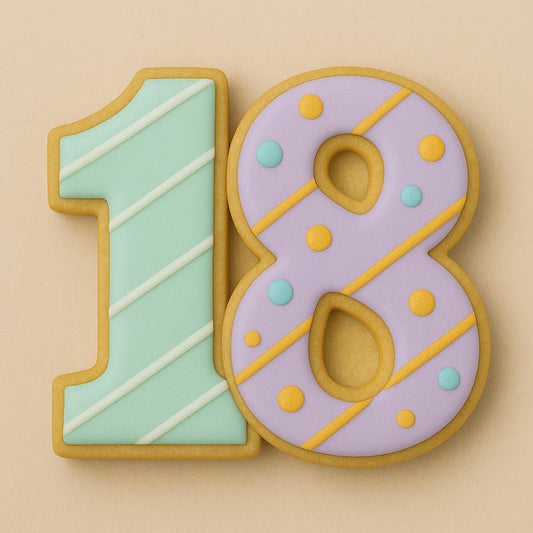 A sugar cookie shaped like the number 18, decorated with pastel mint green and lavender icing. The number one has diagonal white stripes, and the number eight features yellow diagonal lines and colorful dots.