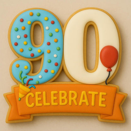 A sugar cookie shaped like the number 90, decorated with blue and cream icing. The number 9 is covered in rainbow sprinkles and a small confetti popper, the number 0 has a red balloon, and an orange banner below reads “CELEBRATE.”
