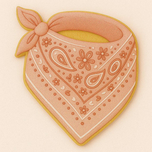 A sugar cookie shaped like a folded bandana, decorated in soft terracotta pink icing with intricate floral and paisley detailing, tied in a knot at the top corner.