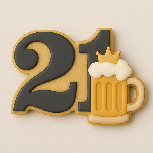 A sugar cookie shaped like the number 21, decorated with matte black icing and featuring a golden beer mug with white foam and a small crown on top, symbolizing a 21st birthday celebration.