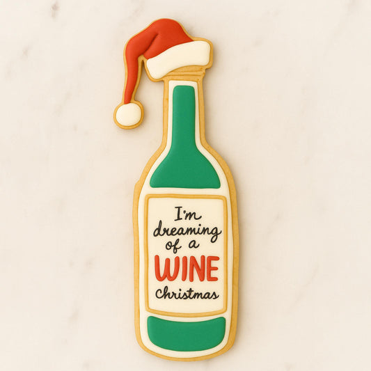 Decorated sugar cookie shaped like a wine bottle with a Santa hat and the phrase “I’m dreaming of a wine Christmas.”